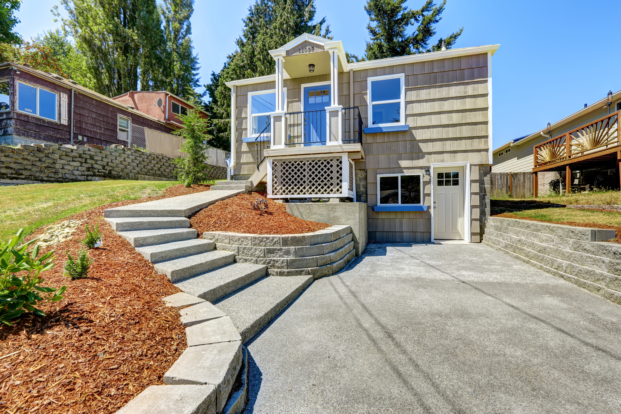 Clapboard sidinig house with walkout deck and concrete walkway